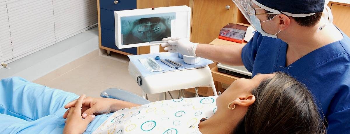 Dentist showing patient image of teeth